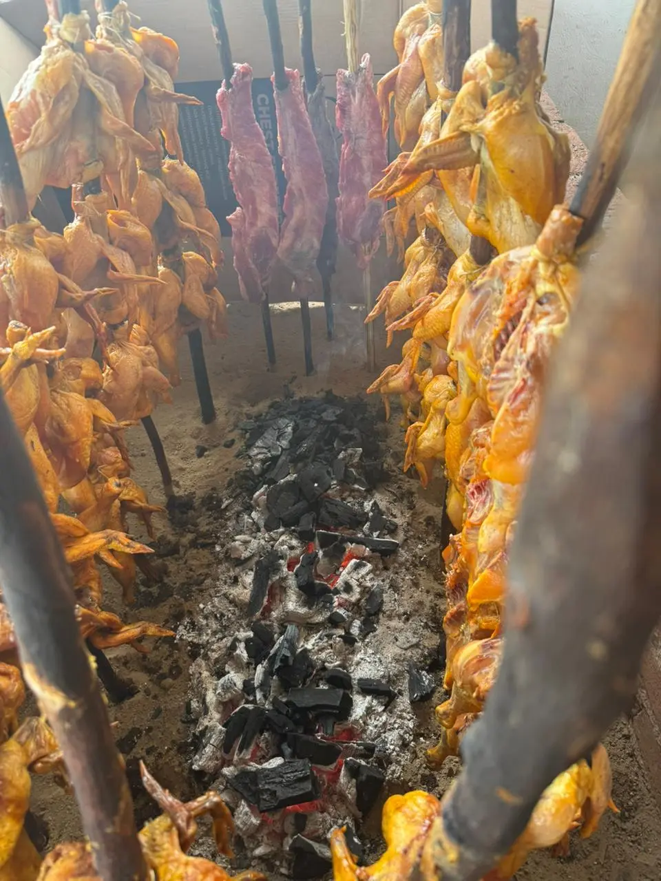 Carbón y pollos en vara